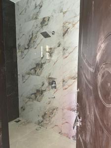 a bathroom with a marble shower with a door at Holy spirit Arul lobo Peace in Kalyānpur