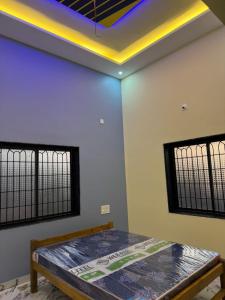a room with a bed and two windows at Holy spirit Arul lobo Peace in Kalyānpur