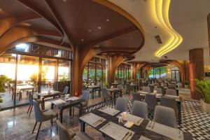 a restaurant with wooden ceilings and tables and chairs at Langco Bay Retreat in Lang Co +107 photos