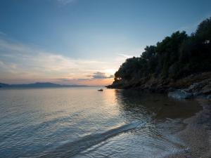 a beach with the sun setting on the water at Villa Aquilo in Megali Ammos