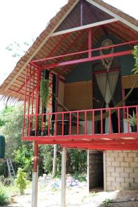 a red house with a balcony in front of it at Presente in Ko Phayam +31 photos