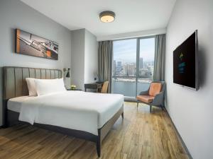 a hotel room with a bed and a window at La Yarda Hotel Guangzhou in Guangzhou