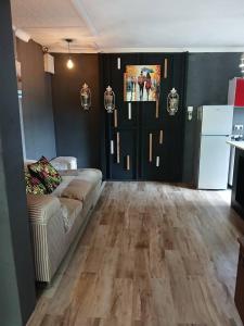 a living room with a couch and a wooden floor at Urban Villa 25 in Gaborone