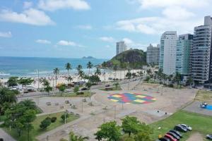 a park in front of a beach with the ocean at Apartamento em Guarujá - Praia da Enseada in Guarujá