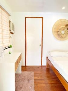 a bedroom with a bed and a table and a door at KnowWell Siargao Nâked in General Luna