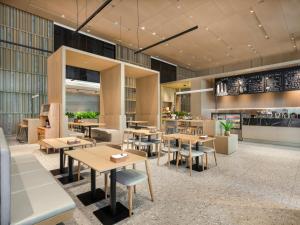 a restaurant with tables and chairs in a room at La Yarda Hotel Guangzhou in Guangzhou