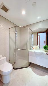 a bathroom with a shower and a toilet and a sink at LEÉ BOISE Hà Nội - Luxury Apartment in Vinhomes Times City in Hanoi