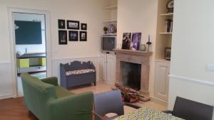 sala de estar con chimenea y sillas verdes en Villa sul mare, en Francavilla al Mare