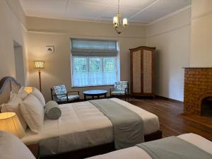 a bedroom with two beds and a fireplace at Watawala Tea Plantation Bungalow in Rozella