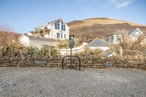 a house on a hill with a stone fence at UPPER BEACH HOUSE in Portreath