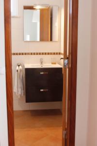 a bathroom with a sink and a mirror at Alojamento Local Mira Mar in Zambujeira do Mar