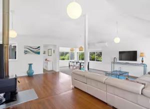 un salon avec un canapé blanc et une télévision dans l'établissement Seabreeze at One Mile, à Boat Harbour