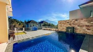 a swimming pool in the backyard of a house at SpringHills Villa Panderman Batu - Private Pool in Tlekung