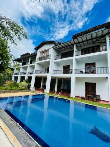 a hotel with a swimming pool in front of a building at Amelia Resort in Sigiriya
