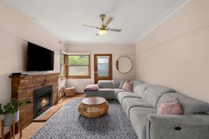 a living room with a couch and a fireplace at Glendarra in Point Lonsdale