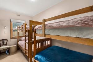 a room with three bunk beds in a house at Glendarra in Point Lonsdale
