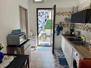 a kitchen with a sink and a door to a patio at Casa AZZURRA in Giovinazzo