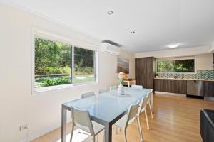 a dining room with a blue table and chairs at At Melaleuca 3 in Point Lookout