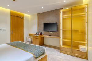 a hotel room with a bed and a flat screen tv at Hotel Sannidhi Emerald in Raigīr
