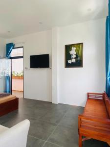 a living room with a couch and a tv on a wall at Green Homestay Tuy Hòa in Liên Trì (4)