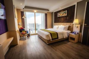 una camera d'albergo con un letto, una scrivania e una finestra di The Bazaar Hotel Bangkok a Bangkok