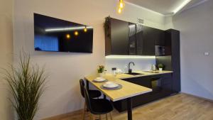 a kitchen with a wooden table and black cabinets at Räpina Studio Apartment in Räpina