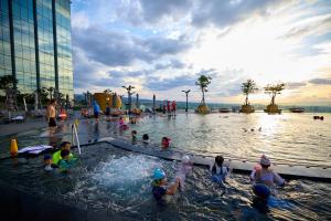 a group of children playing in a swimming pool at Grand Hyatt Jeju in Jeju