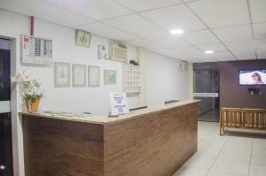 a hospital room with a reception counter and a tv at Pousada Bronzatto in Garopaba