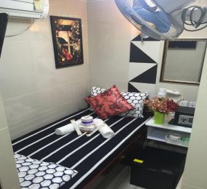 una habitación con un banco de rayas blanco y negro en Skylark Hostel, en Hong Kong