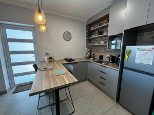 a kitchen with a wooden table and a refrigerator at Prospect Cottage in Walmer