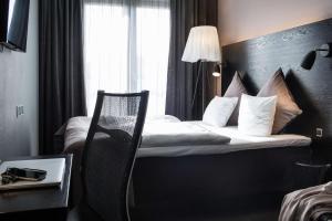 a hotel room with a bed with a chair and a window at Scandic Front in Copenhagen