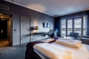 a bedroom with a large bed with a large window at Scandic Front in Copenhagen