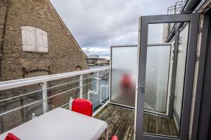 a balcony with a table and a red chair at Scandic Front in Copenhagen