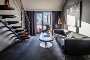 a living room with a couch and a staircase at Scandic Front in Copenhagen