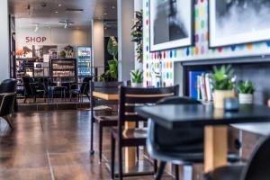 a restaurant with tables and chairs and a shop at Scandic Front in Copenhagen