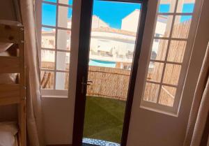 an open door with a view of a pool at Suites Aronas-hébergements climatisés rive droite plein centre ville in Le Grau-du-Roi