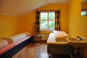 a room with two beds and a sink and a window at Liseth Pensjonat og Hyttetun in Garden