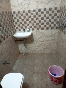 een badkamer met een wastafel, een toilet en een mand bij Divine Blessings in Prayagraj
