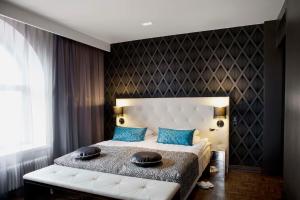 a bedroom with a large bed with blue pillows at Scandic Paasi in Helsinki