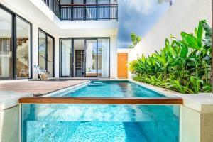 an indoor swimming pool in a villa with a house at Jobon Villas by Great Bali Villas in Uluwatu