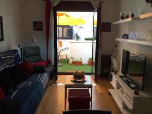 sala de estar con sofá azul y TV en Mai Apartment II, en Las Palmas de Gran Canaria