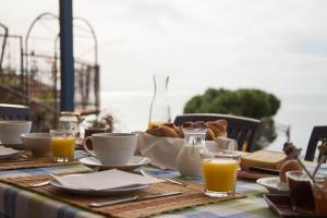 una mesa con una cesta de pan y tazas de zumo de naranja en B&B La Mimosa del Golfo en Ospedaletti