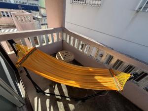 石垣島にあるOhaco Hostel Ishigakiの建物のバルコニーにハンモック