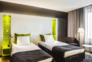 a hotel room with two beds and a chair at Scandic Tampere Station in Tampere +37 photos