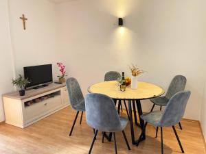 a dining room with a table and chairs and a tv at Apartman Silvana in Risika