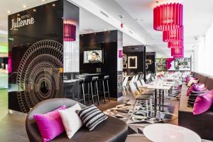 a restaurant with chairs and tables and pink chandeliers at Scandic Tampere Station in Tampere