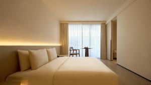 una camera d'albergo con un letto grande e una finestra di 西塘光向度艺术酒店WNDR Hotel Xitang a Jiaxing