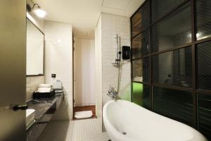 ein Badezimmer mit Badewanne und Dusche in der Unterkunft Hotel The Designers Jongro in Seoul + 85 Fotos