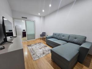 ein Wohnzimmer mit Sofa und Fernseher in der Unterkunft Rin Elegance Apartament in Bukarest