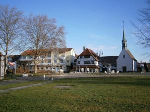 uma igreja com um grande edifício e um campo de relva em Gästehaus Lamprecht em Uhldingen-Mühlhofen